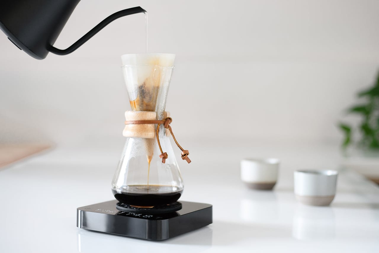 Pearl S weighing a pour-over brew under a Chemex