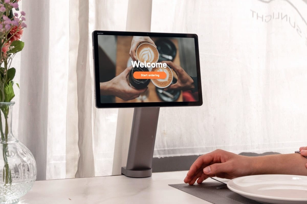 CPad on the table-side stand showing a self-service ordering screen in a café