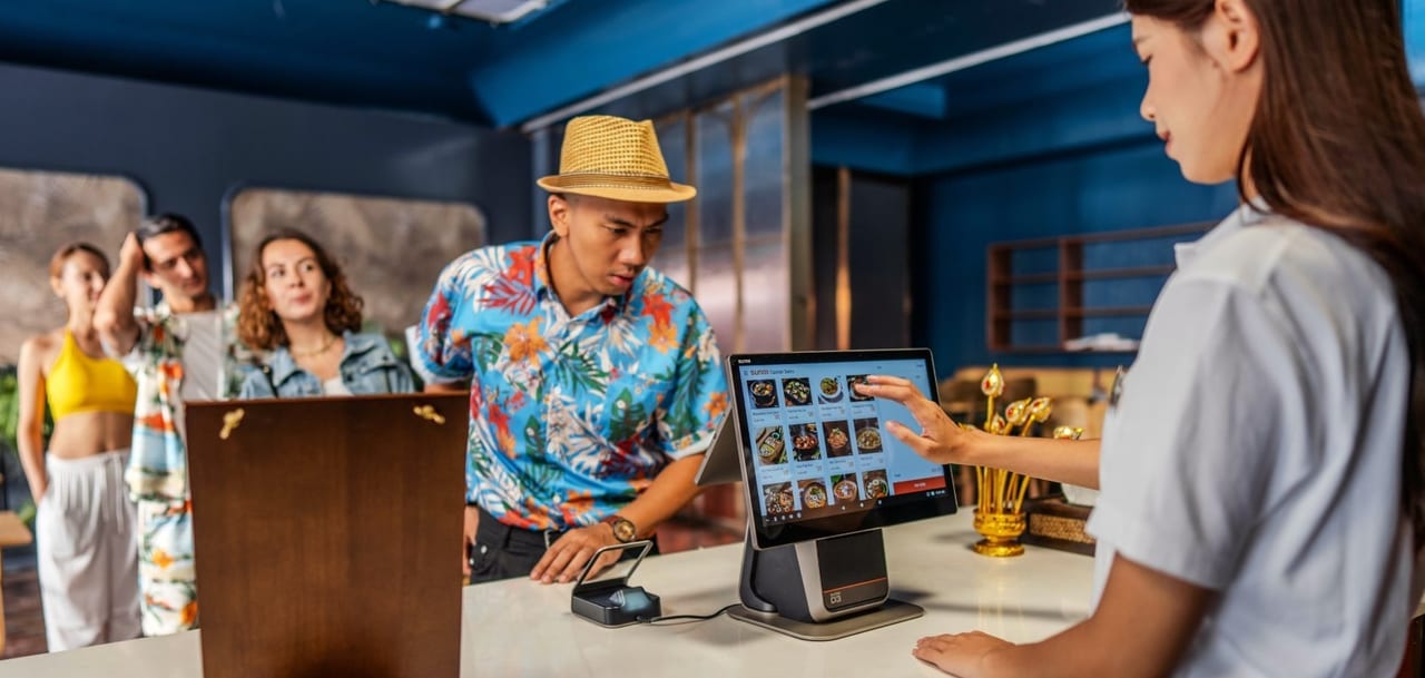 A cashier rings up an order on the SUNMI D3 at a busy counter